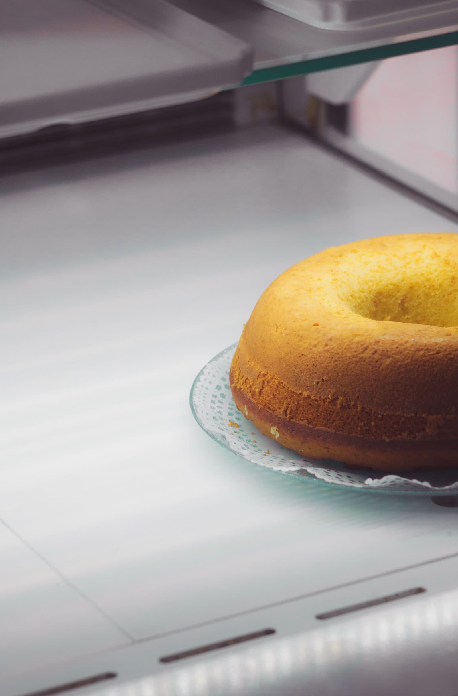 A bundt cake on a plate stored inside a refrigerator
