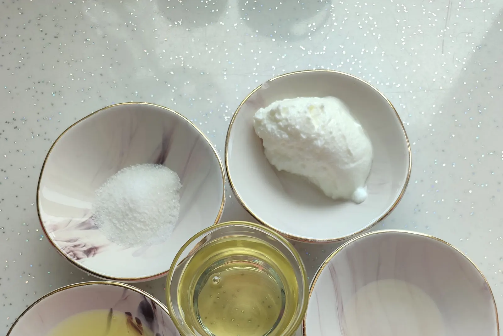 A flat lay of baking ingredients including egg, sugar, and baking powder