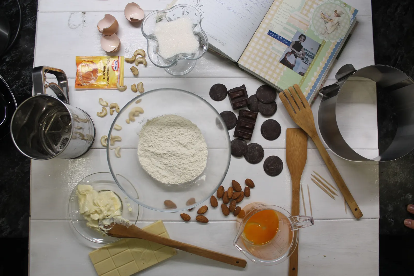 An overhead flat lay of baking tools and ingredients arranged on a kitchen counter