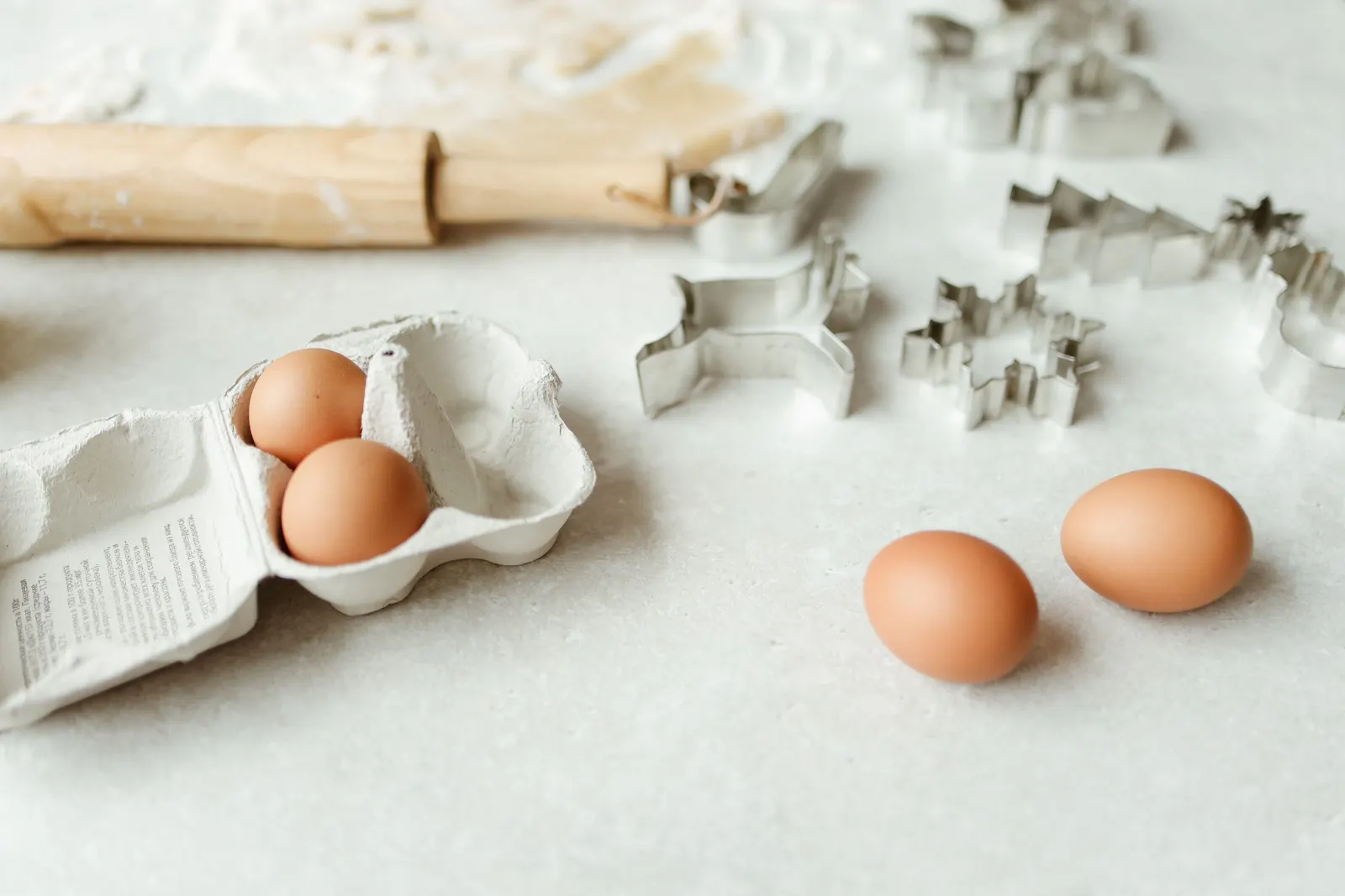 Brown eggs and baking tools arranged on a kitchen table