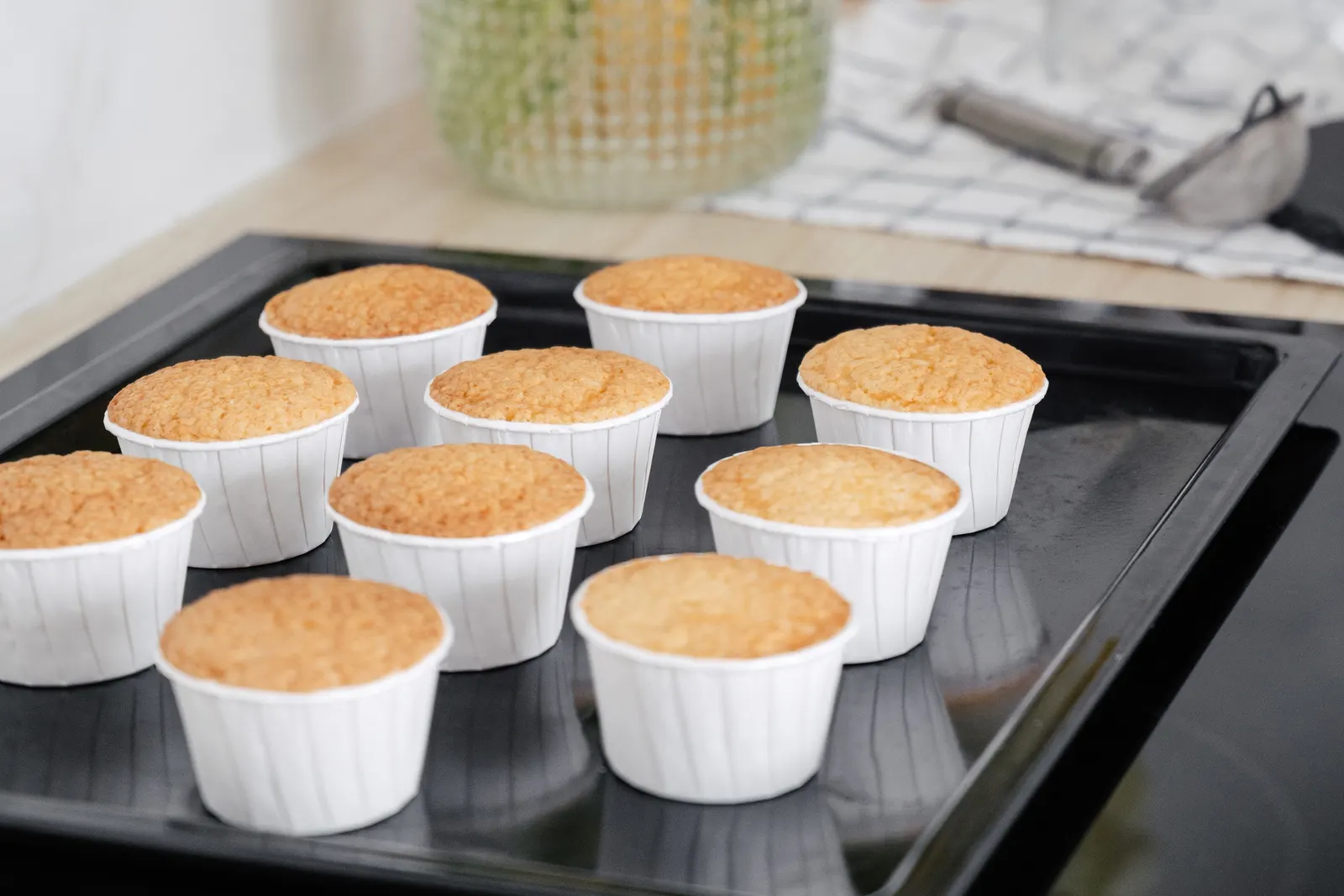Freshly baked cupcakes on a baking tray in a home kitchen