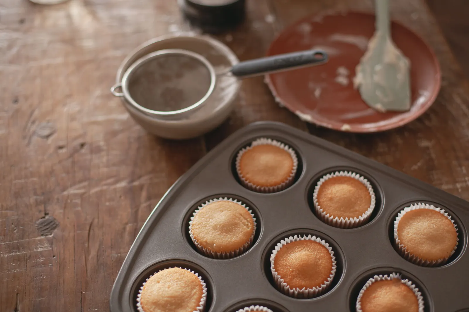 Freshly baked cupcakes cooling in a muffin tin