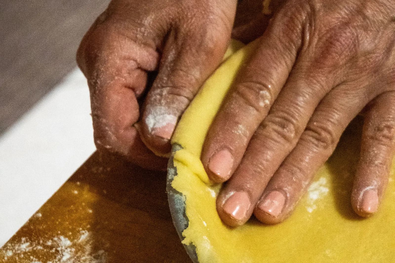 Close-up of hands shaping pie crust dough at home