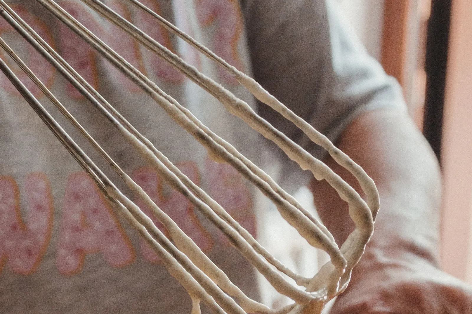 A person mixing cake batter in a bowl with a whisk