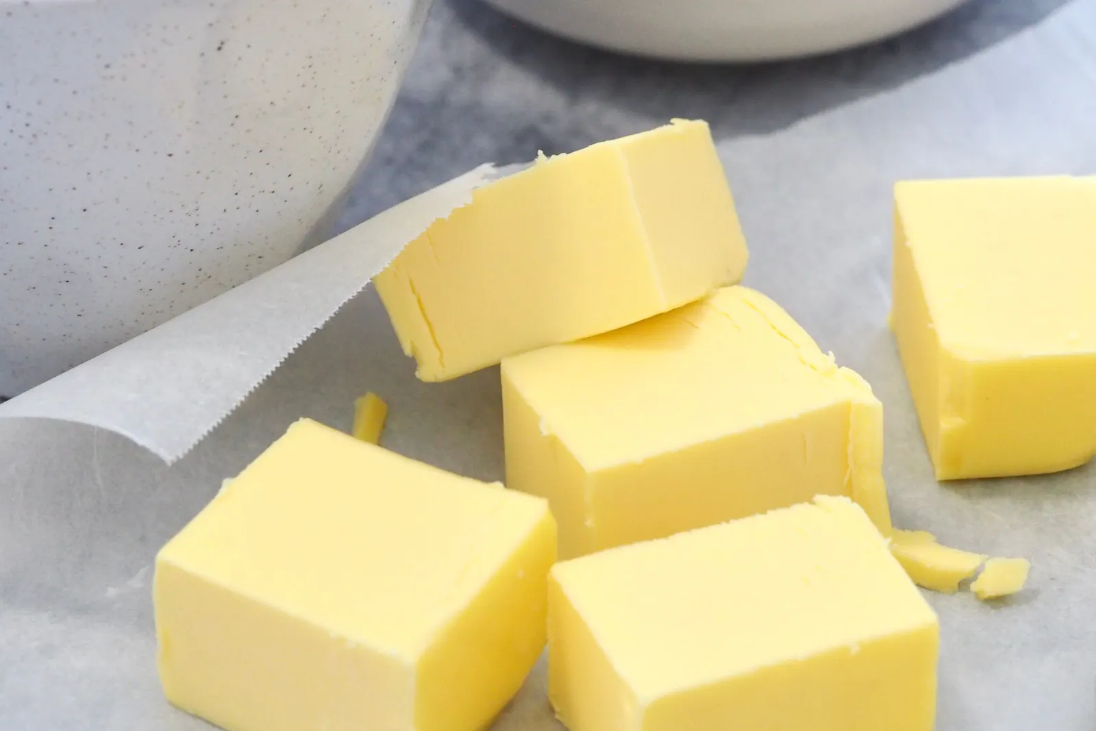 Cubed butter and flour arranged on a marble kitchen counter