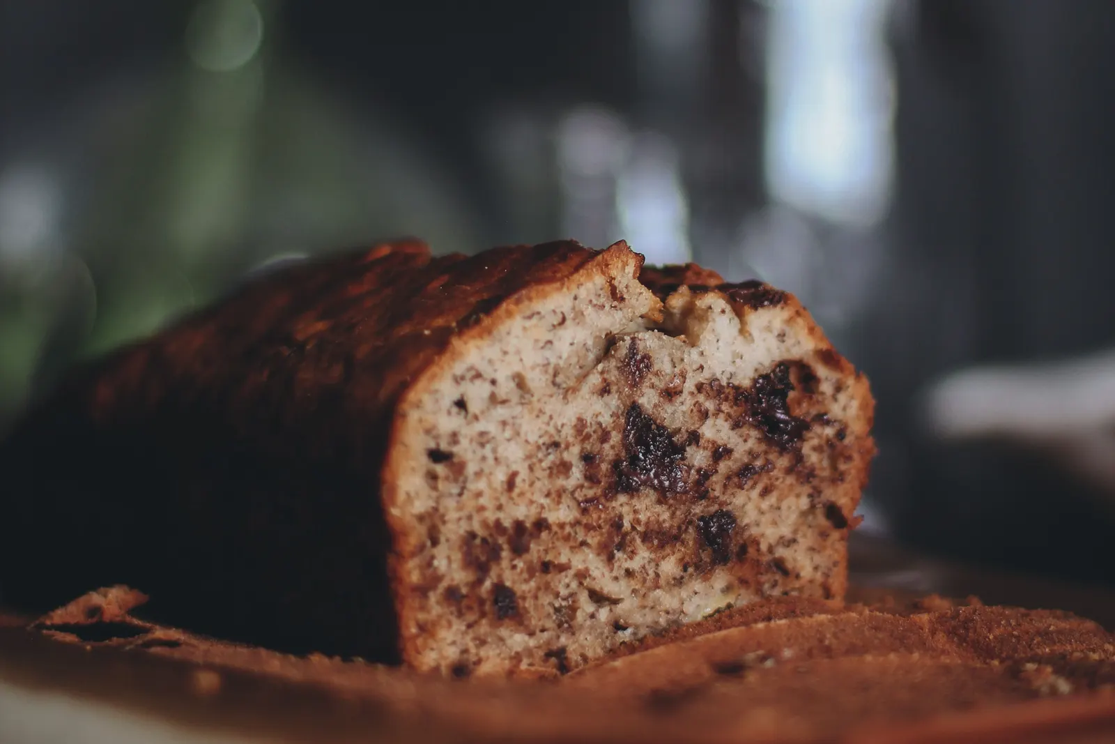 A whole freshly baked loaf of bread on a wooden cutting board