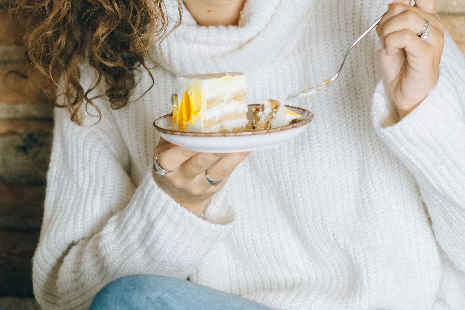 A smiling woman enjoying a slice of cake